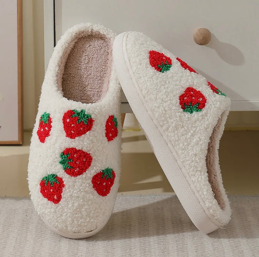 Pair of white slippers with red strawberry pattern