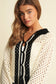 Woman wearing a black and white patterned cardigan 
